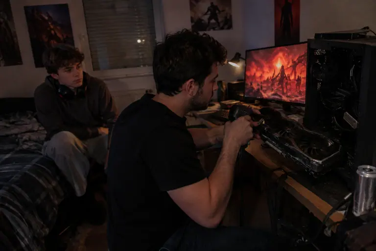 À Rennes, tard le soir, un jeune homme dépoussière la grande carte graphique de son PC pendant que son petit frère attend devant l’écran rougeoyant