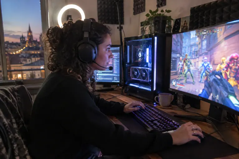 Dans un petit studio de streaming à Bordeaux, une jeune femme casquée joue à un jeu de tir coloré devant un écran rapide et une lampe annulaire