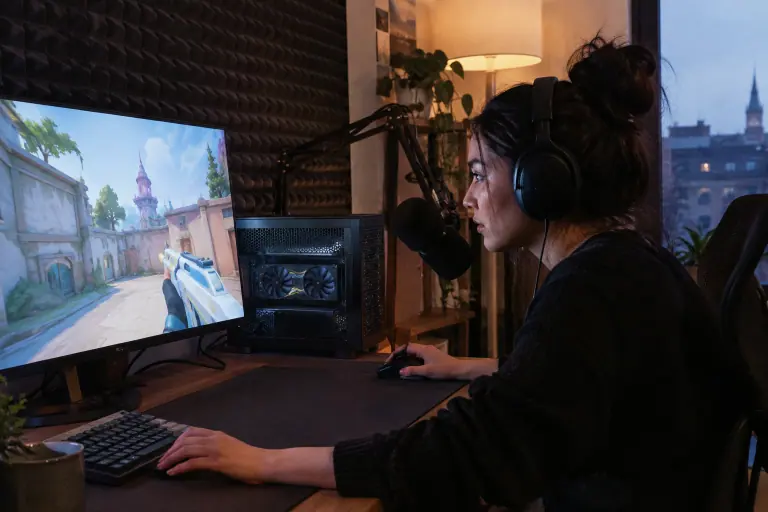 Dans un petit coin de streaming à Nantes, une joueuse casquée se penche vers un écran esport, à côté d’un PC compact à carte graphique courte