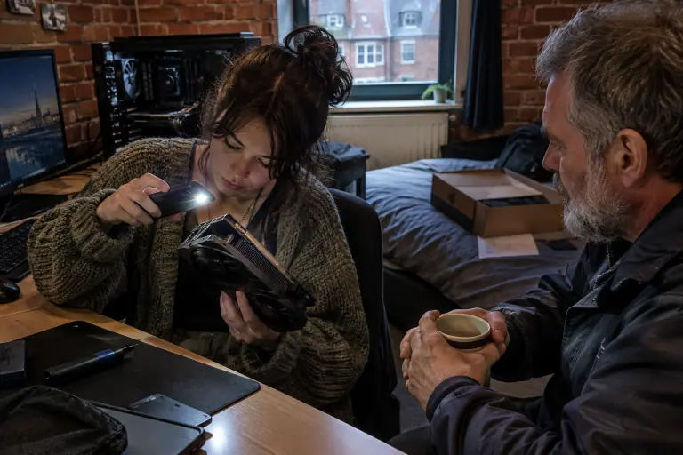 Dans un studio lillois, une étudiante inspecte à la lampe de son téléphone une carte graphique d’occasion, sous le regard du vendeur